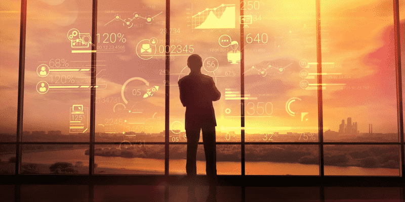 man looks out the window at the big city, against the background of the graph