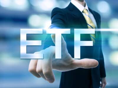 Businessman pointing at ETF (Exchange Traded Funds) on blurred city background