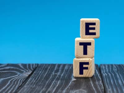 concept word ETF on wooden cubes on a blue background. Technology concept