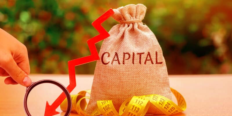 Money bag with the word Capital and arrow down. Fall in the level of authorized capital. Drop in return on equity. The export of fund abroad in order to more reliable and profitable investment.