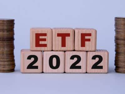 ETF 2022 (Exchange Traded Fund) - acronym on wooden cubes on a light background with coins