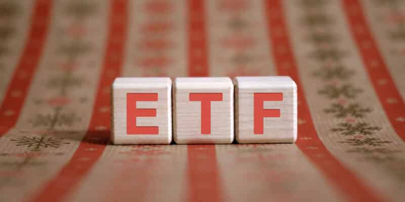 ETF - Exchange Traded Fund - financial business concept. Wooden cubes on a color table.