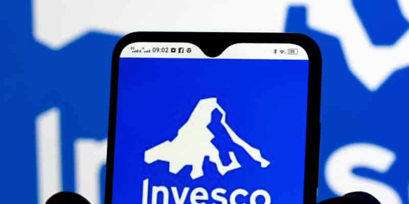 In this photo illustration Invesco Limited logo seen displayed on a smartphone in the background.